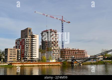 Basel, Schweiz - April 2022: Turmdrehkran arbeitet am Bau neuer Wohngebäude am Rheinufer Stockfoto