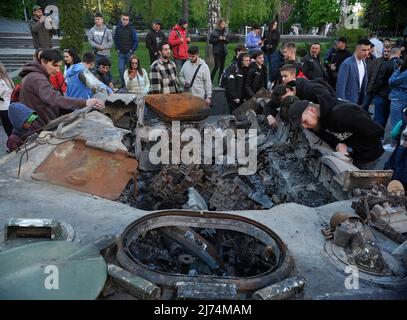 Nicht exklusiv: VINNYZJA, UKRAINE - 5. MAI 2022 - die Menschen betrachten einen russischen Panzer und einen APC, der bei schweren Kämpfen in der Nähe von Bucha und Irpin, Kiew Regi, zerstört wurde Stockfoto