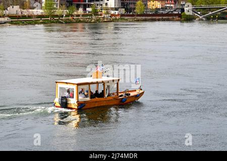 Basel, Schweiz - April 2022: Kleines Wassertaxi auf dem Rhein, der durch die Stadt fließt Stockfoto