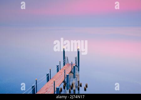 Pinke Abendstimmung über dem Bodensee mit beleuchtem Badesteg, Horn im Kanton Thurgau, Schweiz Stockfoto