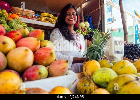 Lächelnde indonesische Geschäftsfrau in kerala goa verkauft Obst- und Gemüsefarm Stockfoto