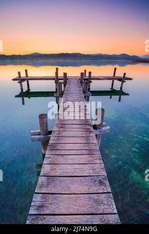 Boardwalk am Pfäffiker-See bei Sonnenaufgang im Hintergrund, Blick auf Bachtel und Glaernisch im Hintergrund, Schweiz, Pfäffikon Stockfoto