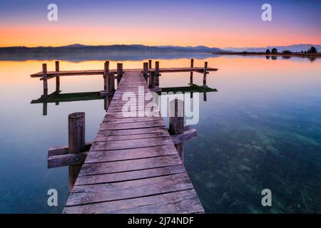 Boardwalk am Pfäffiker-See bei Sonnenaufgang im Hintergrund, Blick auf Bachtel und Glaernisch im Hintergrund, Schweiz, Pfäffikon Stockfoto