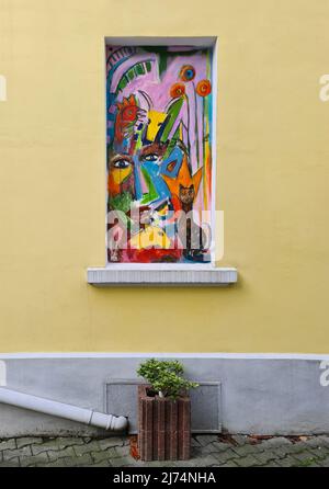 Bunt gemaltes Bild auf einem gemauerten Fenster, Deutschland