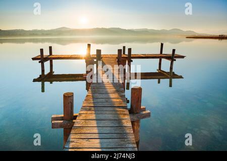 Boardwalk am Pfäffiker-See bei Sonnenaufgang im Hintergrund, Blick auf Bachtel und Glaernisch im Hintergrund, Schweiz, Pfäffikon Stockfoto