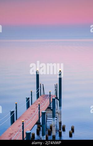 Pinke Abendstimmung über dem Bodensee mit beleuchtem Badesteg, Horn im Kanton Thurgau, Schweiz Stockfoto