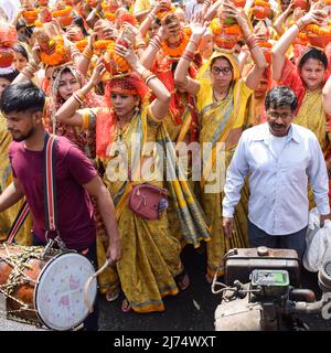 Neu Delhi, Indien April 03 2022 - Frauen mit Kalash am Kopf während des Jagannath-Tempels Mangal Kalash Yatra tragen indische Hindu-Anhänger irdische Töpfe Conta Stockfoto