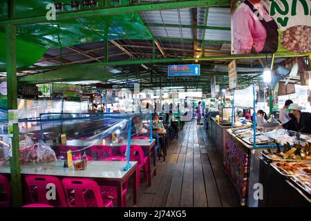 Thailänder, ausländische Reisende, die zu Fuß unterwegs sind, besuchen einen Einkaufsbummel im Supermarkt, einem Holzboot im lokalen Talad Nam Lumphaya Tempel oder im Wat Lam Phaya Floating Stockfoto