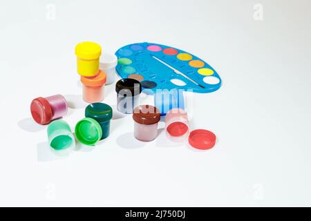 Gläser mit Gouache mehrfarbiger Farbe, Palette, Pinsel. Draufsicht.Flat Lay. Stockfoto