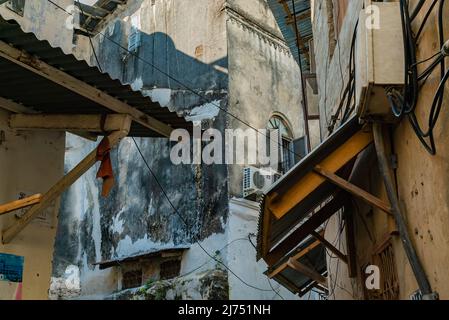 STONE TOWN, TANSANIA - 22. Dezember 2021: Enge Gassen und alte Häuser in Stone Town, Sansibar, Tansania Stockfoto