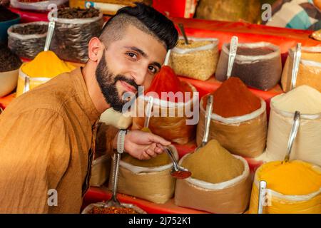 indischer Sallerman zeigt seinen kleinen Laden auf dem arambol goa Markt Stockfoto