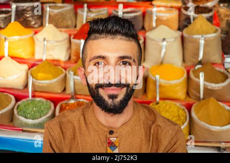 indischer Sallerman zeigt seinen kleinen Laden auf dem arambol goa Markt Stockfoto
