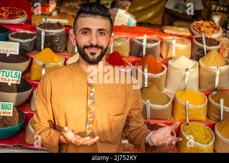 indischer Sallerman zeigt seinen kleinen Laden auf dem arambol goa Markt Stockfoto