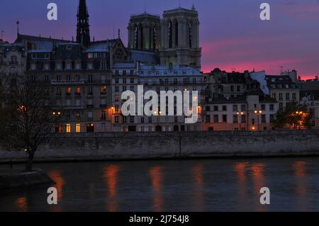 Notre-Dame und die Gebäude entlang des Quai aux Fleurs auf der île la Cité in der Abenddämmerung von pont Louis Philippe am rechten Ufer der seine aus gesehen. Stockfoto