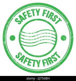 SICHERHEIT ERSTES Wort auf grünem runden Briefmarkenschild geschrieben Stockfoto