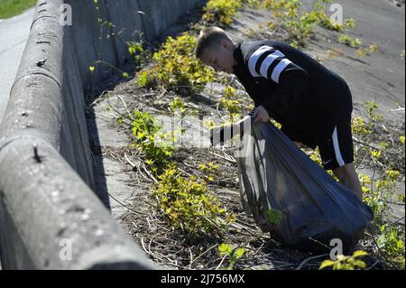 Nicht exklusiv: VINNYZJA, UKRAINE - 5. MAI 2022 - Ein Freiwilliger holt Müll entlang der Uferpromenade des Flusses Pivdennyj Buh, Vinnyzja, Zentralukraine, ab Stockfoto