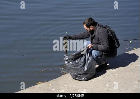 Nicht exklusiv: VINNYTSIA, UKRAINE - 5. MAI 2022 - Ein Freiwilliger holt eine Flasche entlang des Ufers des Flusses Pivdennyi Buh, Vinnytsia, Zentralbritisch Stockfoto