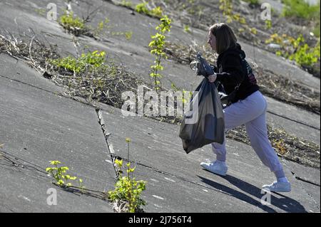 Nicht exklusiv: VINNYZJA, UKRAINE - 5. MAI 2022 - Ein Freiwilliger holt Müll entlang der Uferpromenade des Flusses Pivdennyj Buh, Vinnyzja, Zentralukraine, ab Stockfoto