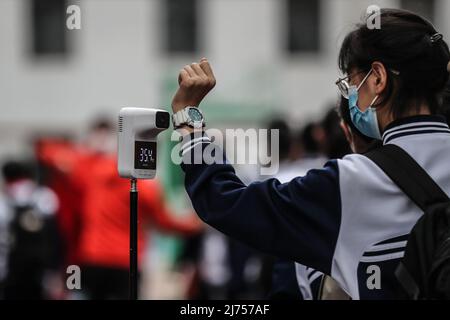 (220506) -- SHENYANG, 6. Mai 2022 (Xinhua) -- Eine Schülerin wird ihre Körpertemperatur messen, bevor sie eine Mittelschule in Shenyang, nordöstlich der chinesischen Provinz Liaoning, besucht, 6. Mai 2022. Die höheren und jüngeren Schulen nahmen am Freitag den Unterricht für die Absolventen der Stadt Shenyang wieder auf. (Xinhua/Pan Yulong) Stockfoto