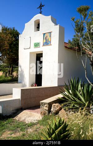 Santa Pola, Alicante, Spanien - 6. Mai 2022: Fassade der Hermitage of Santa Pola Leuchtturm Seeseite unter blauem Himmel Stockfoto