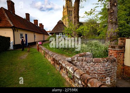 Thaxted Essex England UK Mai 2022 Thaxted Kirche mit Almenhäusern auf der linken Seite vom alten Kissing Gate aus gesehen Stockfoto