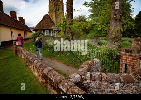 Thaxted Essex England UK Mai 2022 Thaxted Kirche mit Almenhäusern auf der linken Seite vom alten Kissing Gate aus gesehen Stockfoto