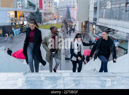 Eine Gruppe von multirassischen Geschäftsleuten geht die Sterne hoch und lächelt Stockfoto