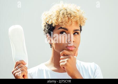 Mixed Race hispanic brasilianisches Mädchen mit Hygienepads auf weißem Hintergrund im Studio und schneeweißem Lächeln Stockfoto