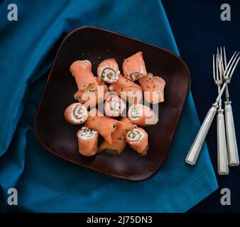 Geräucherte Lachsrollen mit Frischkäse und Schnittlauch Stockfoto