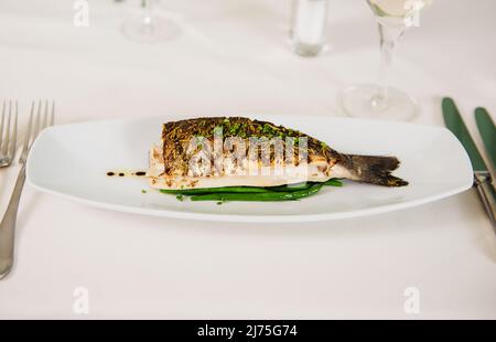 Gegrillter Fisch mit Herbes de Provence und frisch geschnittenem Schnittlauch Stockfoto