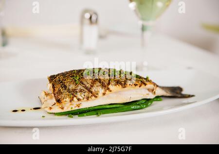 Gegrillter Fisch mit Herbes de Provence und frisch geschnittenem Schnittlauch Stockfoto