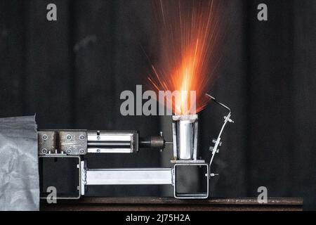 06. Mai 2022, Niedersachsen, Goslar: Eine Lithium-Ionen-Batterie havers während eines Nageltests im Rahmen einer Demonstration in einem Container auf dem Gelände des Brandschutzunternehmens Stöbich. Aussteller des Innovationsforums der Recyclingregion Harz machten auf die Gefahren von Batterien in Elektroautos aufmerksam. Foto: Swen Pförtner/dpa Stockfoto