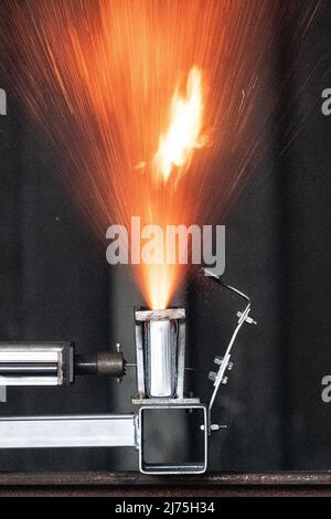 06. Mai 2022, Niedersachsen, Goslar: Eine Lithium-Ionen-Batterie havers während eines Nageltests im Rahmen einer Demonstration in einem Container auf dem Gelände des Brandschutzunternehmens Stöbich. Aussteller des Innovationsforums der Recyclingregion Harz machten auf die Gefahren von Batterien in Elektroautos aufmerksam. Foto: Swen Pförtner/dpa Stockfoto