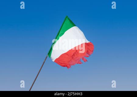 Eine italienische Flagge winkt am blauen Himmel. Italienische Flagge flattert im Wind Stockfoto
