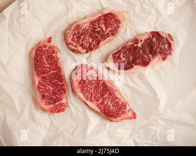 RAW Wagyu Streifen Steaks auf Metzgerpapier Stockfoto