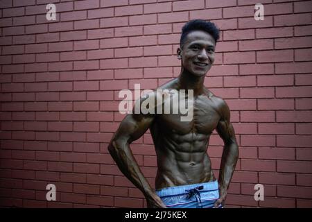 6. Mai 2022, Kathmandu, Nepal: Ein Bodybuilder beugt sich im Hintergrund während der Qualifikationsrunde der bundesweiten Bodybuilding-Meisterschaften von Dharmashree, bei der am Freitag, den 6. Mai 2022, Hunderte Gewichtheber aus dem ganzen Land am Wettbewerb in Kathmandu, Nepal, teilnehmen. (Bild: © Skanda Gautam/ZUMA Press Wire) Stockfoto