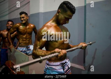 6. Mai 2022, Kathmandu, Nepal: Ein Bodybuilder pumpt seinen Körper im Hintergrund während der Qualifikationsrunde der nationalen Bodybuilding-Meisterschaften von Dharmashree, bei der Hunderte von Gewichtheber aus dem ganzen Land am Freitag, dem 6. Mai 2022, in Kathmandu, Nepal, am Wettbewerb teilnehmen. (Bild: © Skanda Gautam/ZUMA Press Wire) Stockfoto