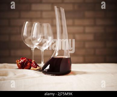 Rotwein in einer Weindekanter mit zwei leeren Glas und Granatapfel Stockfoto