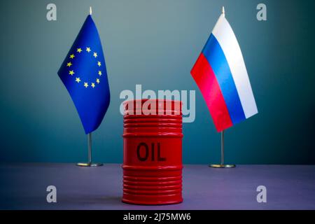 Flaggen der EU und Russlands und ein Barrel Öl als Symbol für Sanktionen. Stockfoto