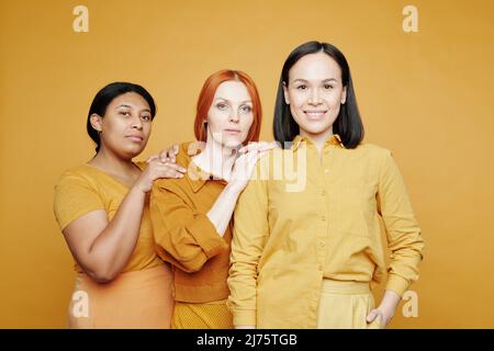 Porträt einer lächelnden jungen asiatischen Frau, die selbstbewusst mit ihren Freundinnen hinter ihr steht Stockfoto