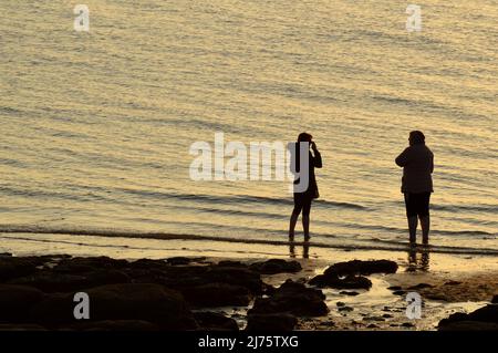 Hunstanton, Norfolk, Großbritannien - 18. April 2021: Silloettes on the Beach, norfolk Stockfoto