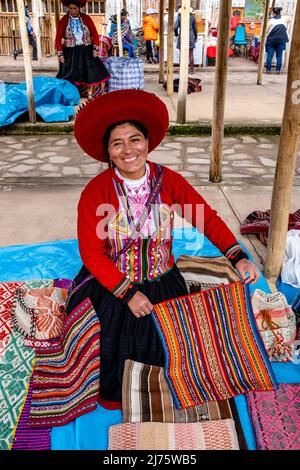 Eine peruanische indigene Quechua-Frau, die Wollhandarbeiten auf dem Sonntagsmarkt im Dorf Chinchero, Region Cusco, Peru verkauft. Stockfoto