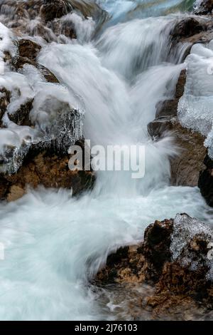 Der Rissbach bei Hinterriss in Tirol im sogenannten eng beim Ahornboden, im Winter bei Schnee und Eis mit markanten Felsen und starkem Durchfluss von klarem Wasser. Stockfoto