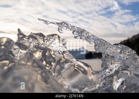 Eis bei Sonnenuntergang am Walchensee im bayerischen Voralpenland mit Sonnenstrahlen. Stockfoto