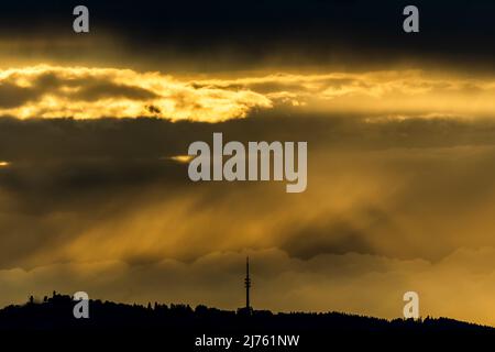 Stürmische Lichtstimmung am Peißenberg bei Weilheim im bayerischen Voralpenland. Auf der linken Seite sehen Sie den Fernsehturm und das Dorf. Stockfoto