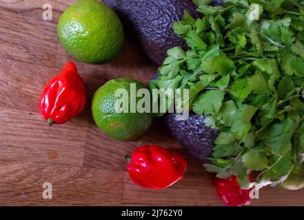 Frische rote Chilischoten aus Scotch Bonnet mit Limetten-Koriander und Avocado-Zutaten zur Herstellung von Guacamole Stockfoto