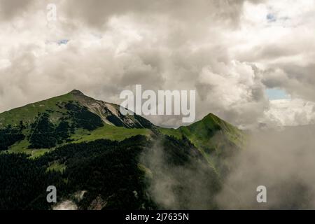 Der Schafreuter, ein beliebter Berg im deutsch-österreichischen Grenzgebiet, im Karwendel, bei dichten Wolken und Regenwetter. Wenn man genau hinschaut, entdeckt man die Hütte in der Mitte des Bildes. Stockfoto