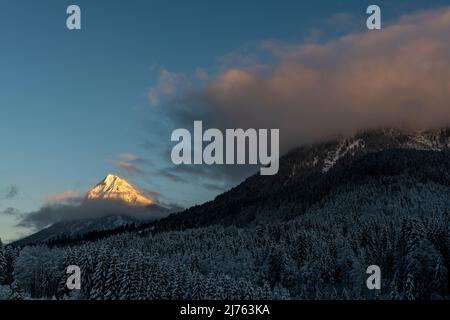 Die Guffert in den Rofan Bergen, während Schnee im Winter in den letzten Abend Licht. Alpenglow beleuchtet nur den Gipfel und ein paar Wolken. Stockfoto