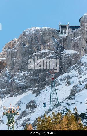 Die Bergstation der Karwendelbahn im Winter mit Schnee, Eis und harten Felsen. Eine Hütte auf dem Weg zum Gebäude. Stockfoto