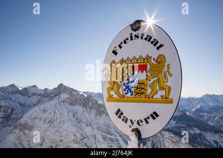 An der Grenze zwischen Tirol (Österreich) und Bayern (Deutschland) am Westkarwendel stehen alte Emailschilder mit dem jeweiligen Wappen, im Hintergrund teilweise das Karwendelgebirge Stockfoto